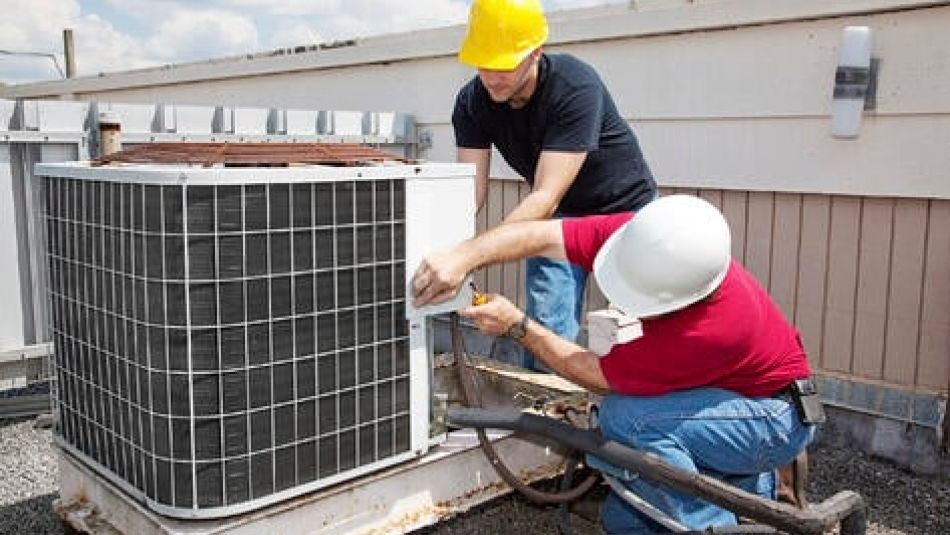 2 HVAC installers workiing on a rooftop HVAC unit