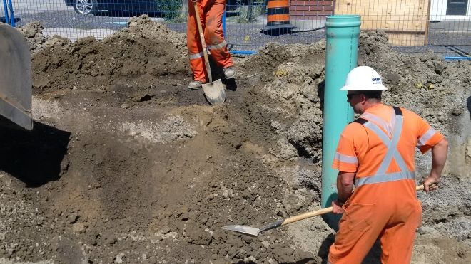 Construction working digging beside gas pipe